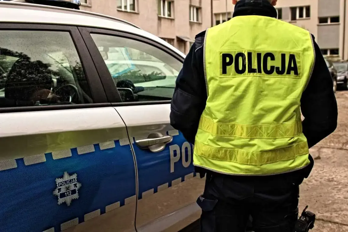 Policjant z Hrubieszowa na tle radiowozu.