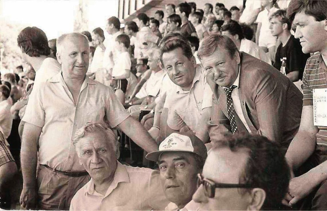 Marian Bizior (pierwszy z lewej) stoi za siedzącym przed nim trenerem reprezentacji polski w piłce nożnej Kazimierzem Górskim.