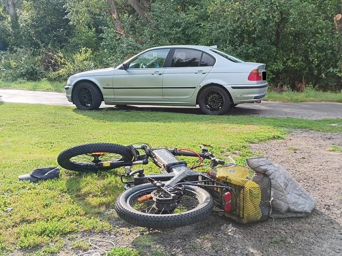 Przewrócony rower na miejscu wypadku w Łaszczowie. W tle samochód BMW.